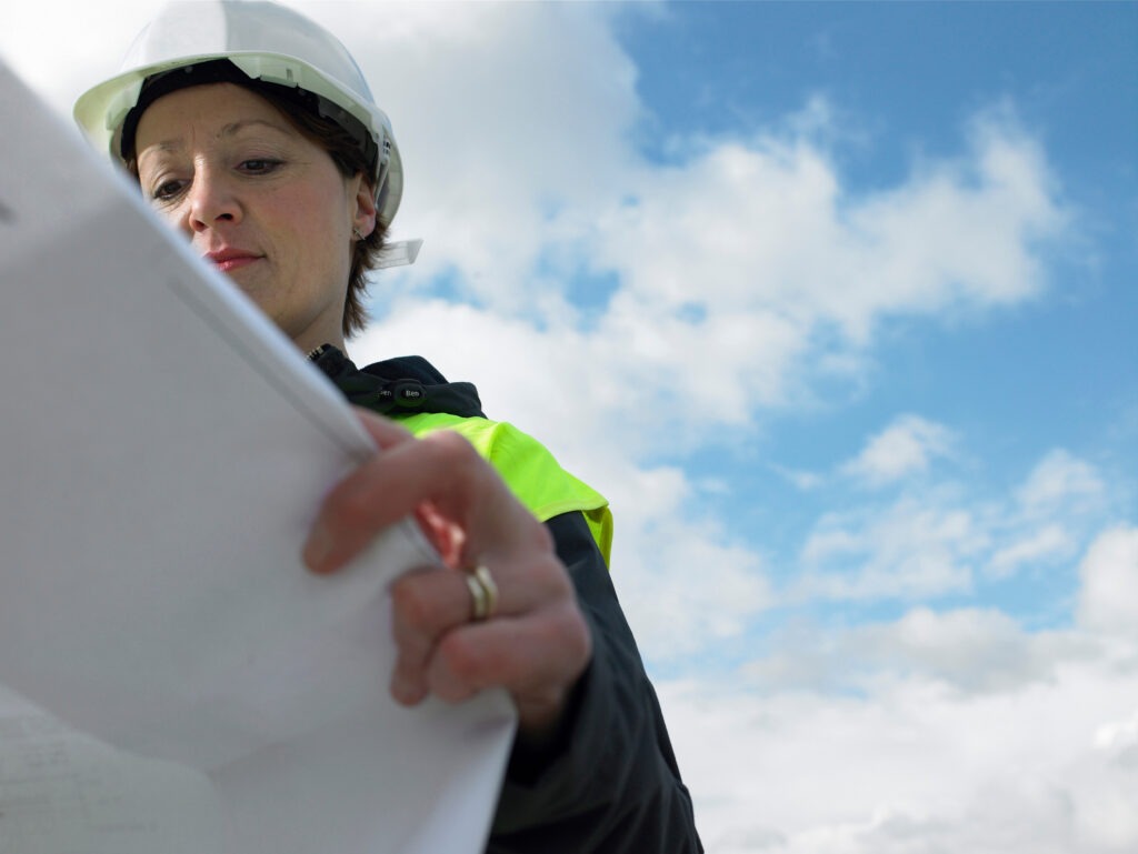Worker examining blueprints on site
